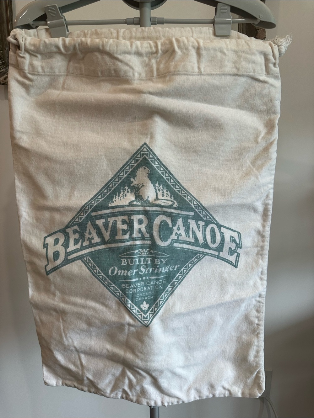 Beaver Canoe Cotton Drawstring Bag in Off-White with Teal Logo